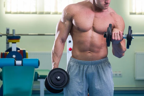 Bodybuilder makes exercises with dumbbells — Stock Photo, Image