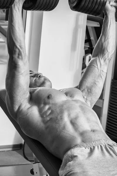 Man aan het werk uit met gewichten in gym — Stockfoto