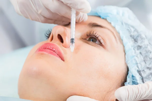 Kosmetolog gör injektion i patientens ansikte — Stockfoto