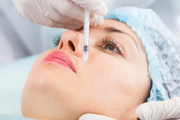 Beautician makes injection into the patient's face — Stock Photo, Image