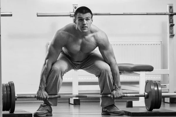 Man makes exercises with barbell — Stock Photo, Image