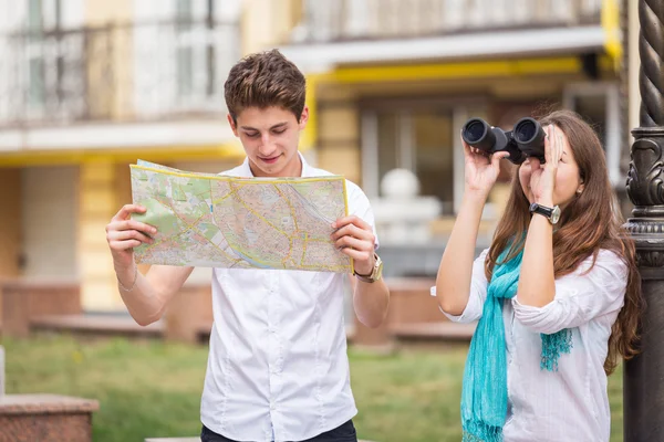 Couple with map and binocular — Stock Photo, Image