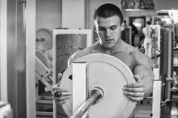 Man makes exercises with barbell — Stock Photo, Image