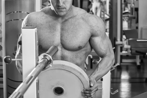 Man makes exercises with barbell — Stock Photo, Image