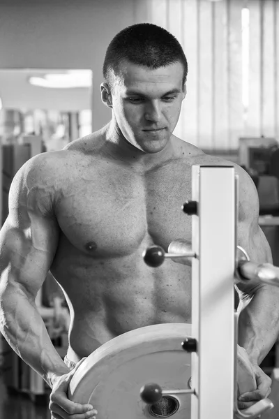 Man makes exercises with barbell — Stock Photo, Image