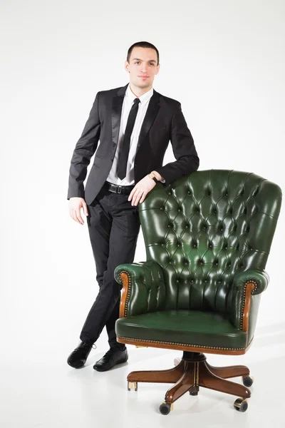 Empresário perto de uma cadeira de couro — Fotografia de Stock