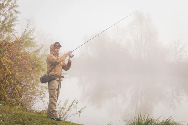 Fisherman standing with spinning — Stock Photo, Image