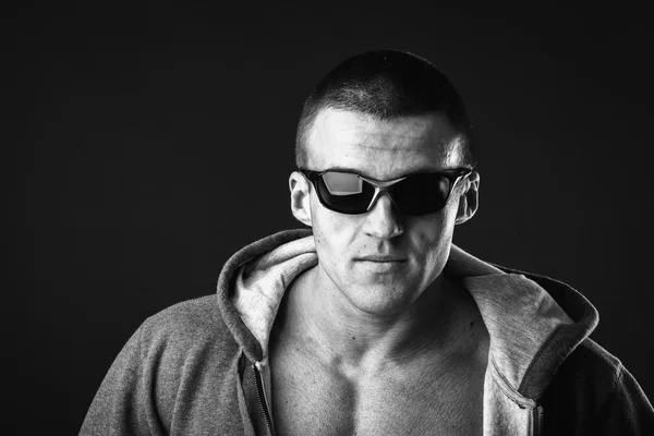 Человек в спортивной куртке и солнцезащитных очках — стоковое фото