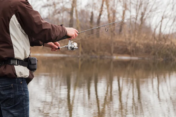 Fisherman holding a light spinning rod — Stock Photo, Image