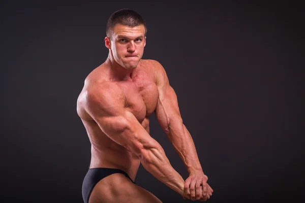 Homem atlético mostrando músculos em suspense — Fotografia de Stock