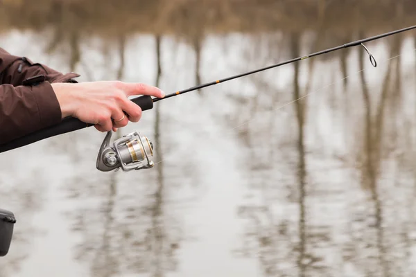 Fisherman standing with spinning — Stock Photo, Image