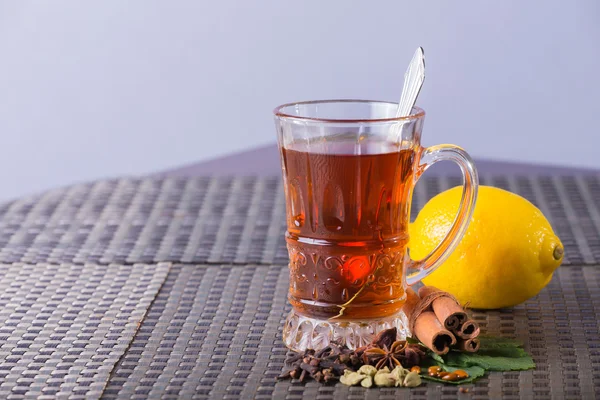 Tea with lemon against light background