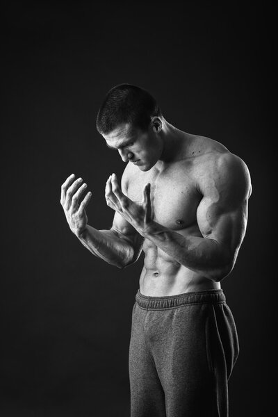 Muscular man posing on a black background