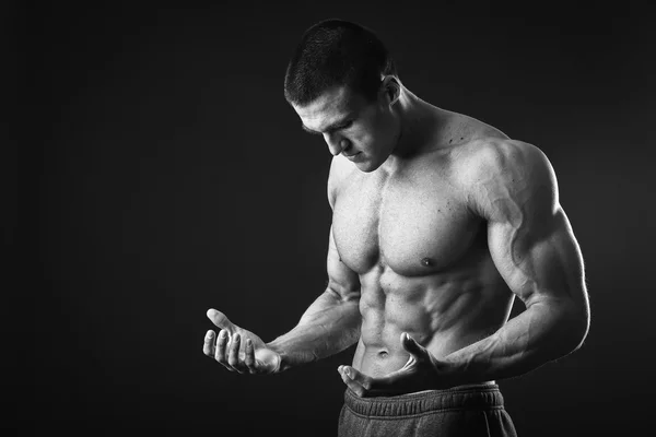 Muskulöser Mann posiert auf schwarzem Hintergrund — Stockfoto