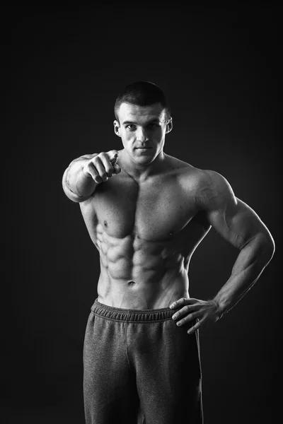 Muscular man posing on a black background — Stock Photo, Image