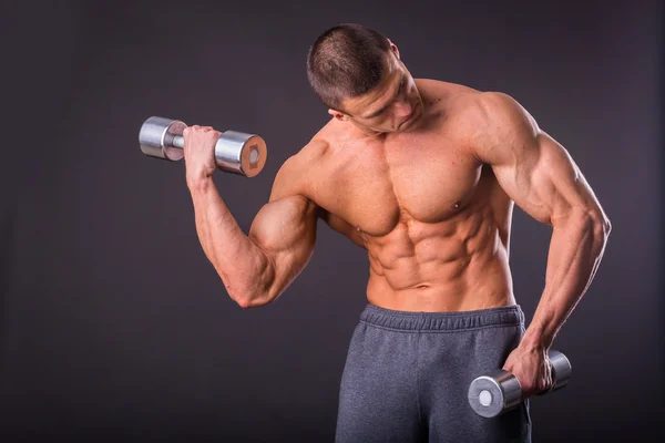 Deportista sosteniendo una mancuernas . — Foto de Stock