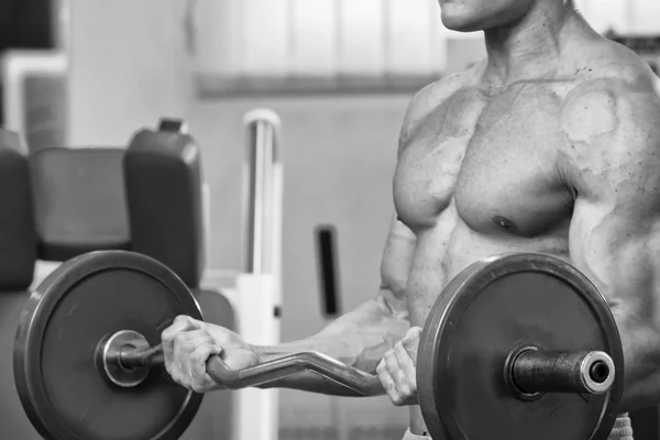 Homem faz exercícios com barra . — Fotografia de Stock