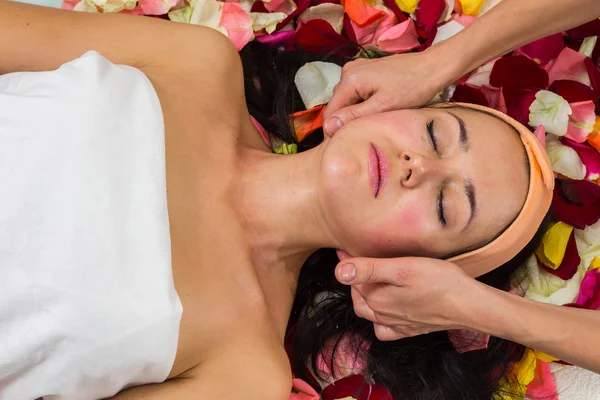 Girl lying on petals in beauty salon