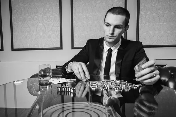 Jovem no casino na mesa de jogos — Fotografia de Stock