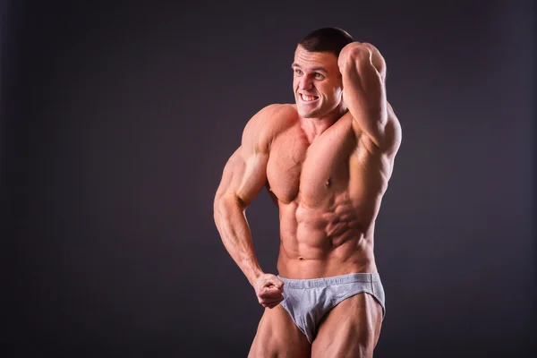 Bodybuilder poseren op een zwarte achtergrond — Stockfoto