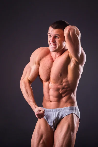 Bodybuilder posant sur un fond noir — Photo