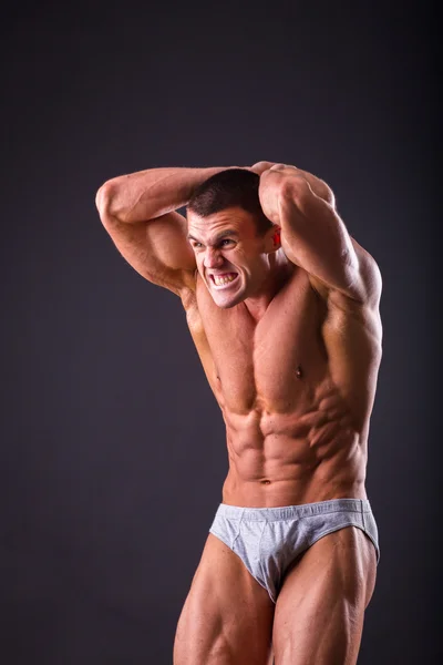 Bodybuilder poseren op een zwarte achtergrond — Stockfoto