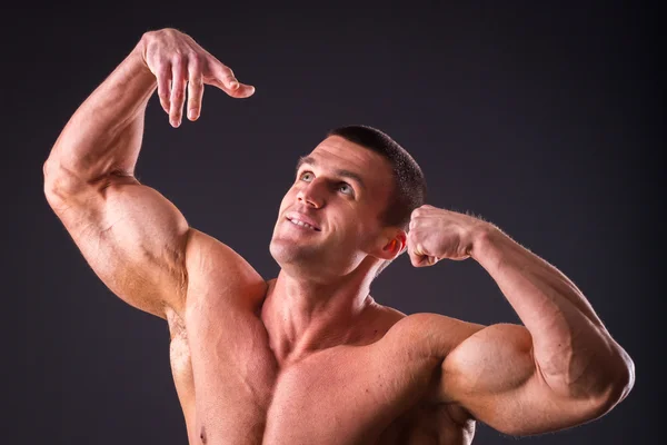 Bodybuilder posiert auf schwarzem Hintergrund — Stockfoto