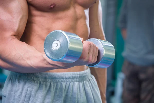 Homem musculoso trabalhando com halteres — Fotografia de Stock