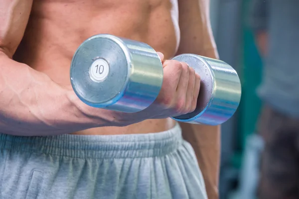 Homem musculoso trabalhando com halteres — Fotografia de Stock