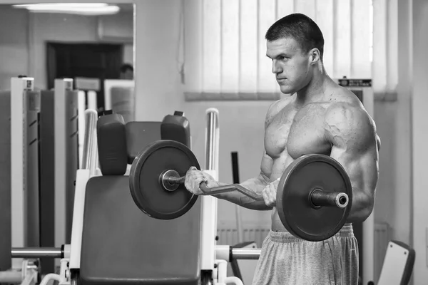 Man makes exercises with barbell — Stock Photo, Image