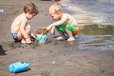 Kumsalda oynarken çocuklar