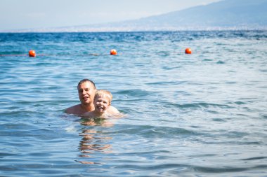 Denizin baba ile yüzme çocuk.