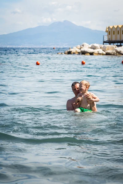 Father and son playing in water — Stock Photo, Image