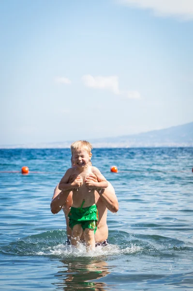 Father and son playing in water — Stock Photo, Image