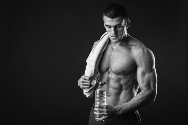 Bir şişe su tutarak atletik erkek