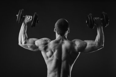 Yakışıklı kaslı adam egzersizleri dumbbells ile yapma