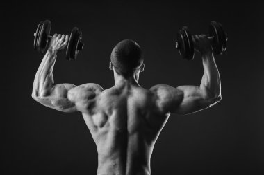 Yakışıklı kaslı adam egzersizleri dumbbells ile yapma