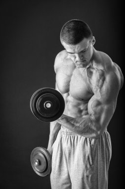 Yakışıklı kaslı adam egzersizleri dumbbells ile yapma