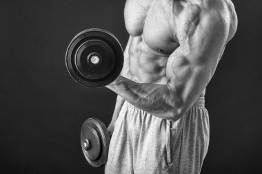 Yakışıklı kaslı adam egzersizleri dumbbells ile yapma
