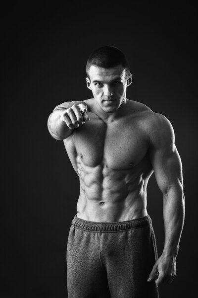 Muscular man pointing with a finger
