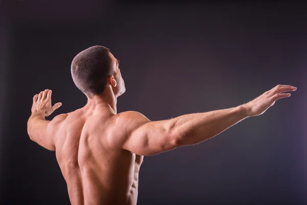 Bodybuilder shows his muscles — Stock Photo, Image