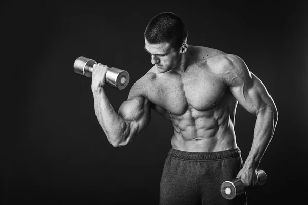 Bonito homem musculoso trabalhando com halteres — Fotografia de Stock