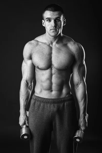 Handsome muscular man working out with dumbbells — Stock Photo, Image