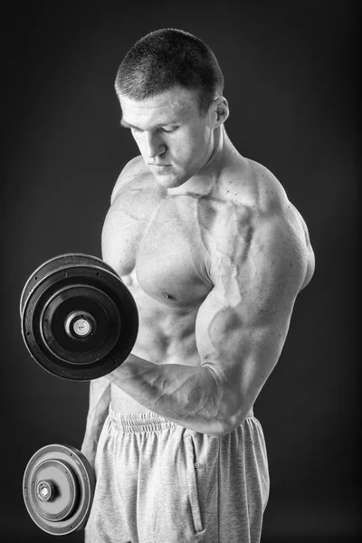 Hombre musculoso guapo haciendo ejercicios con pesas — Foto de Stock