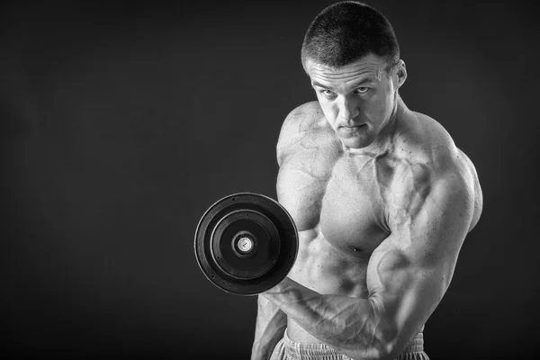 Schöner muskulöser Mann, der mit Hanteln trainiert — Stockfoto