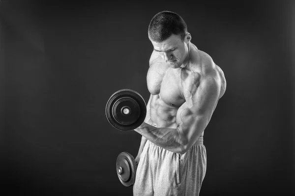 Bonito homem musculoso trabalhando com halteres — Fotografia de Stock