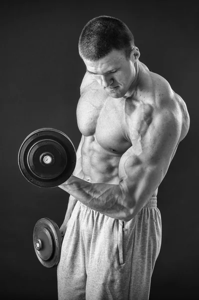 Schöner muskulöser Mann, der mit Hanteln trainiert — Stockfoto