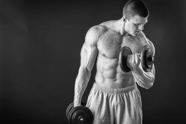 Przystojny mięśni mężczyzna z hantlami — Zdjęcie stockowe