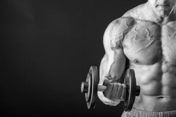 Bonito homem muscular fazendo exercícios com halteres — Fotografia de Stock