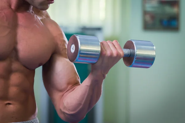 Hombre musculoso guapo haciendo ejercicio con pesas — Foto de Stock